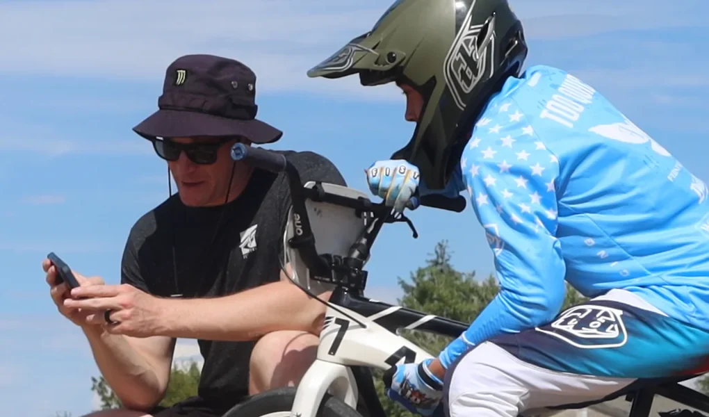 Blake and Connor Fields review a phone screen beside his white bike