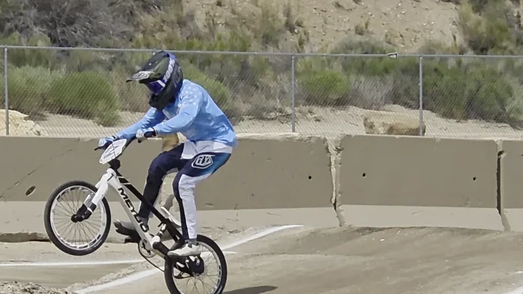 Blake lifts the front wheel of his white bike during the Green River race weekend